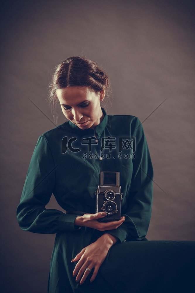 女性复古风格深色长袍与旧相机合