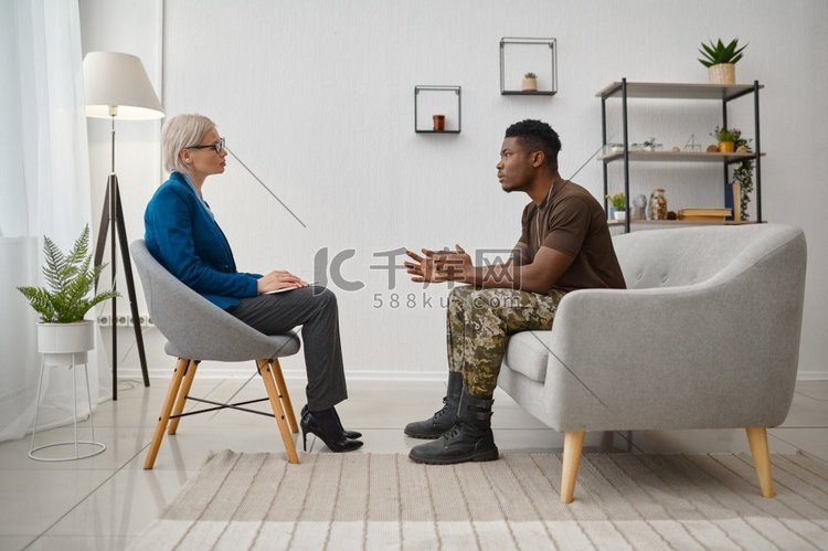 坐在心理学家面前的军人病人。创