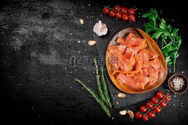 腌鲑鱼在一个木制盘子与绿色。黑