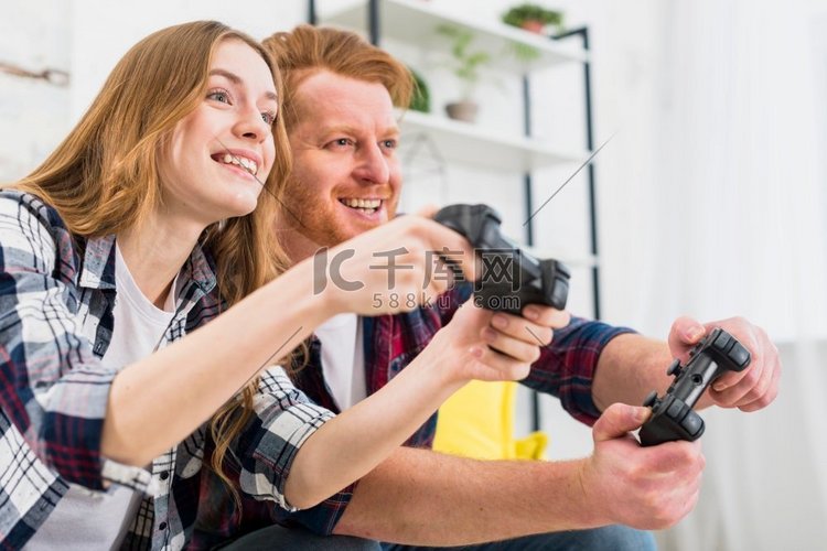 愉快的肖像年轻夫妇玩游戏控制台