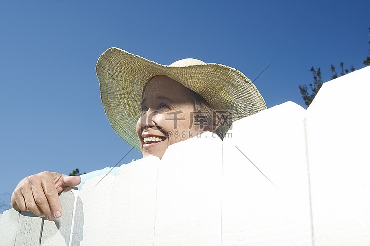 女人凝视花园围栏