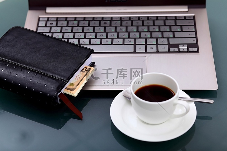 办公桌上摆着一杯咖啡和一本笔记