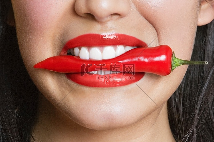 西班牙裔女子咬红辣椒的特写镜头