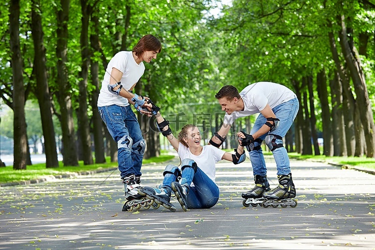 两名年轻男子在轮椅上托起一名倒