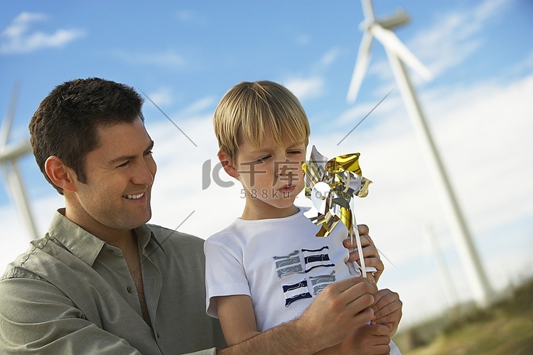 男孩(7-9)和父亲在风电场吹
