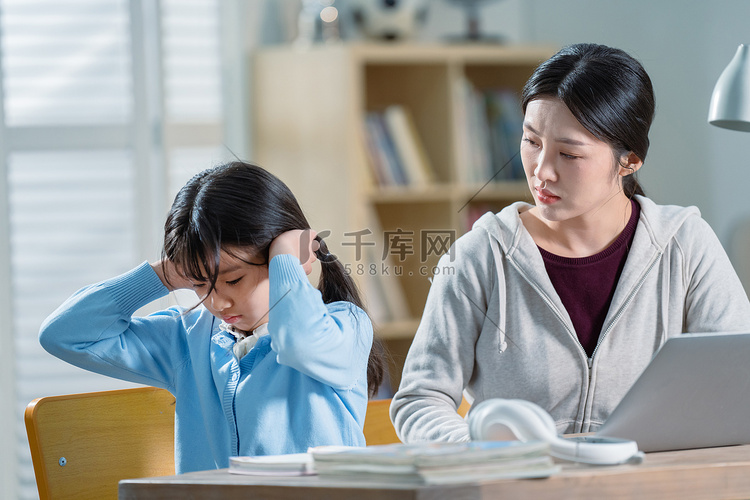 年轻妈妈和做作业的女儿生气