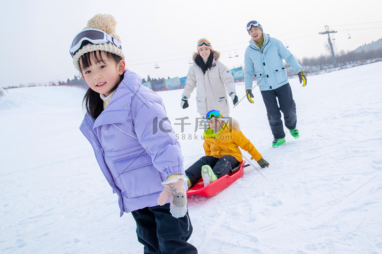 快乐的四口之家玩雪上滑板