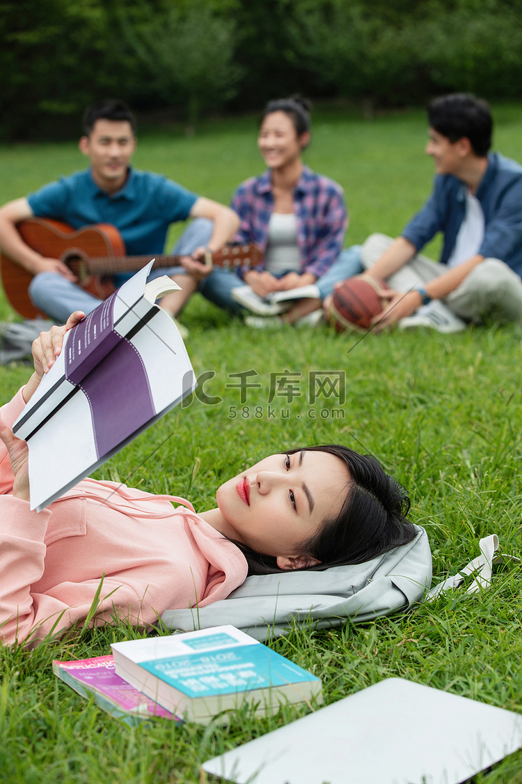 大学生在草地上享受课余时间