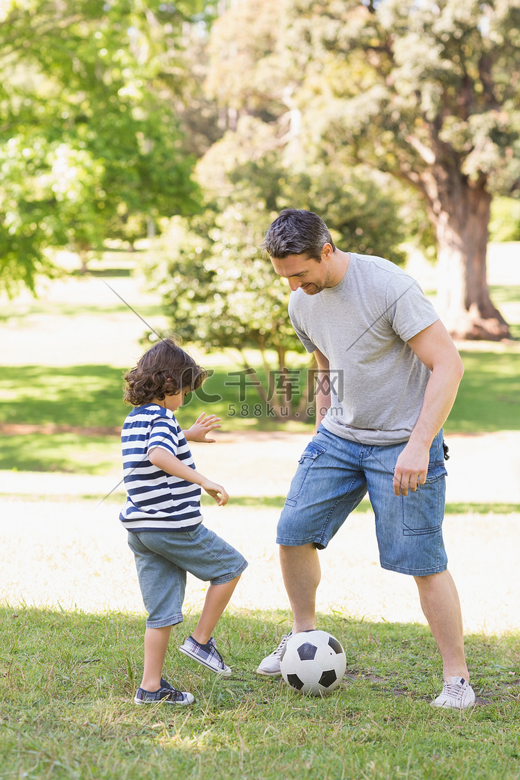 父亲和儿子在公园踢足球