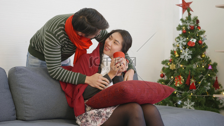爱男人给女人盖毯子坐在沙发上喝