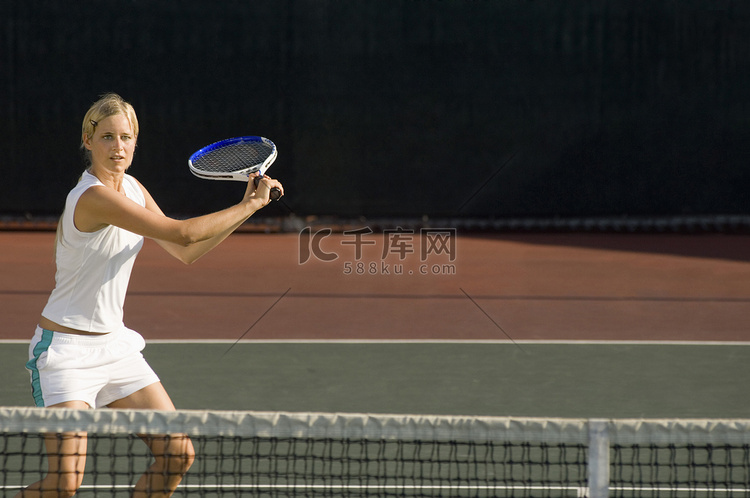 年轻女子网球运动员在球场上挥动