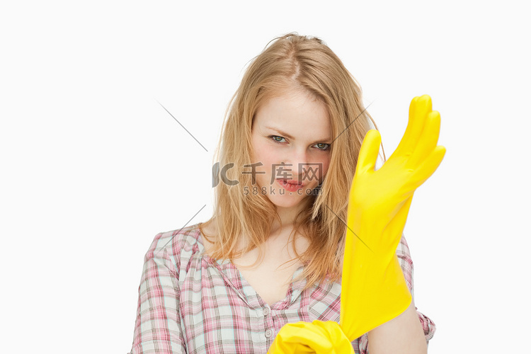 戴清洁手套时皱眉的女人