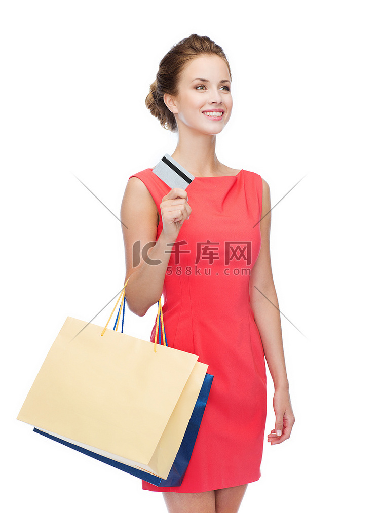 带着购物袋和塑料卡的微笑女人