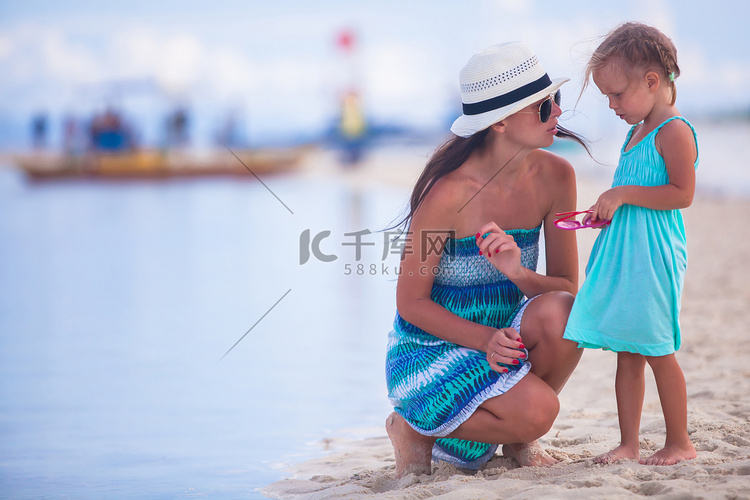 荒岛热带海滩上的小女孩和年轻母