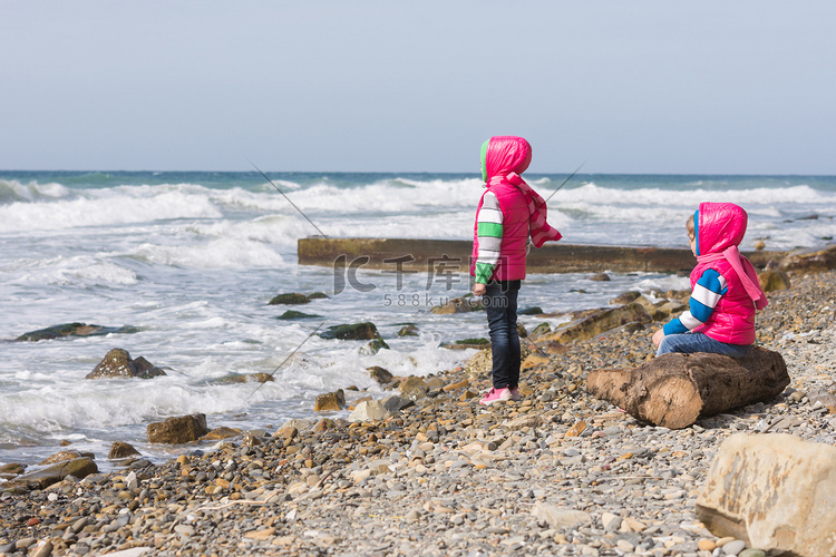 沙滩上的两个女孩望着远方