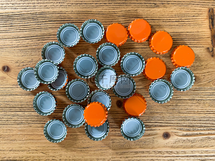 许多橙色啤酒盖，木纹顶部的瓶塞