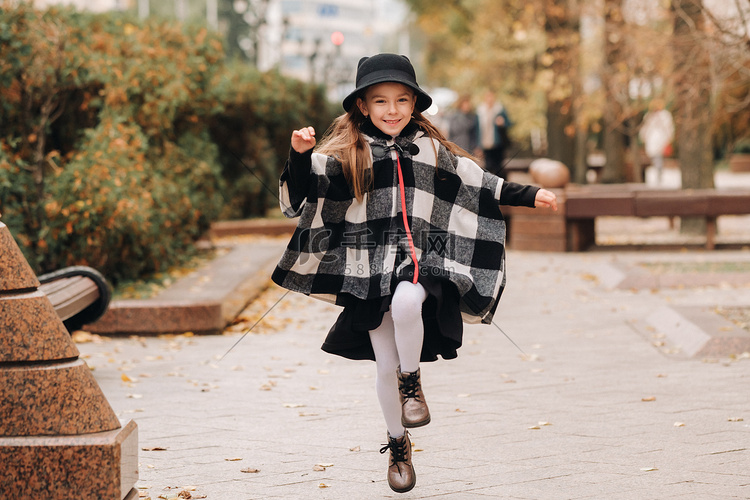 一个戴着帽子的时尚小女孩在秋天