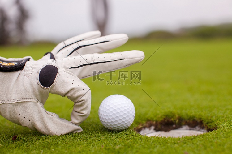 高尔夫球手将高尔夫球推入洞中