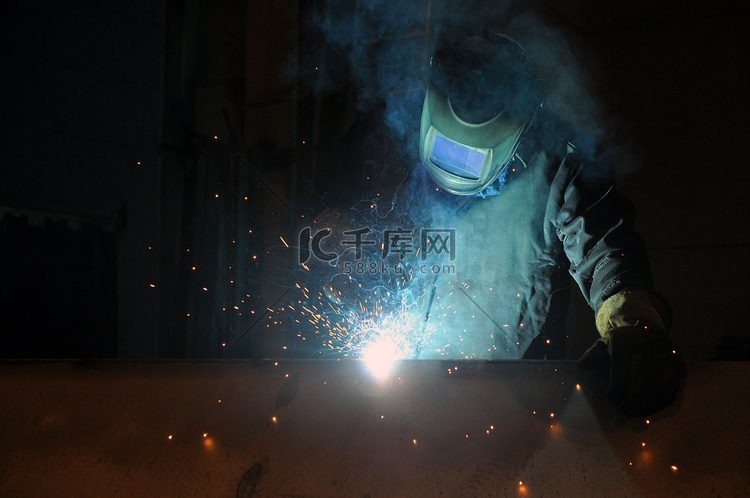 电焊工在工厂焊接金属结构。