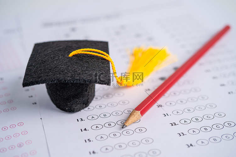 毕业间隙帽子和铅笔在答卷背景上