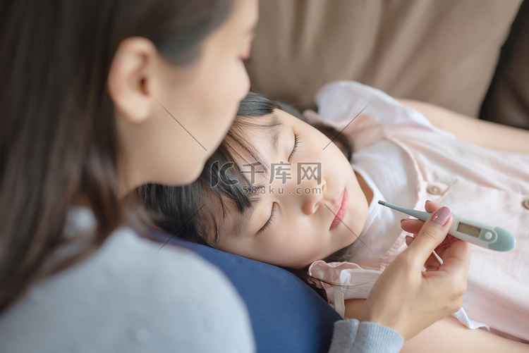亚洲母亲用温度计检查孩子的体温