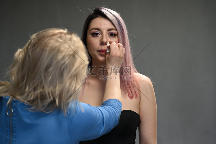 化妆师在模特面前修正妆容