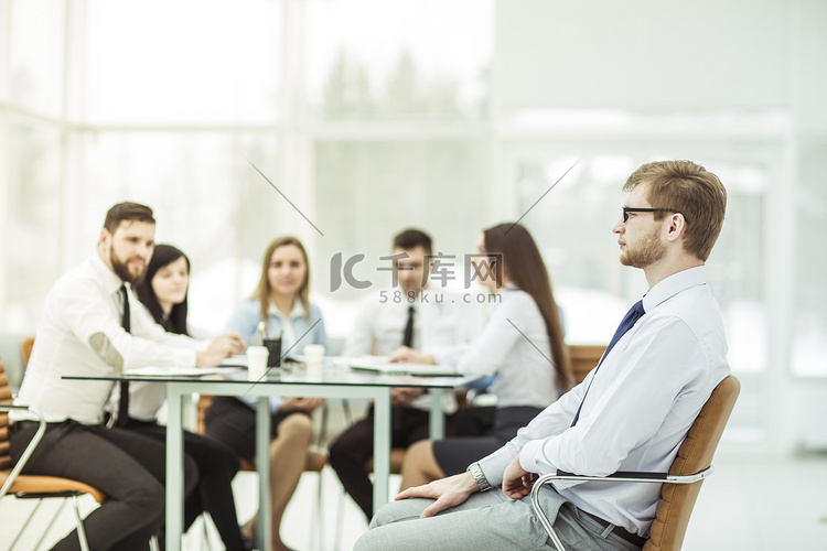 经理坐在办公椅上，业务团队在办