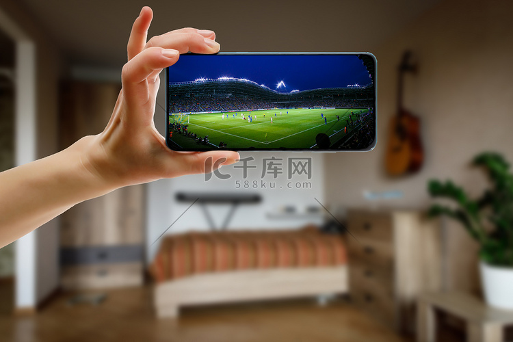 通过智能手机在家观看足球比赛。