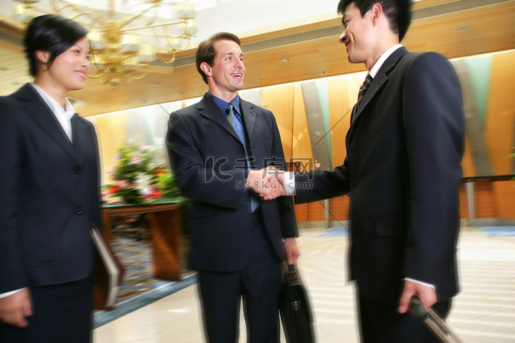 中外商务人士在酒店里握手