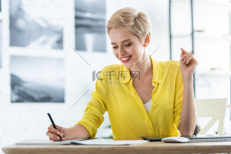 微笑女性自由职业者写在课本在桌