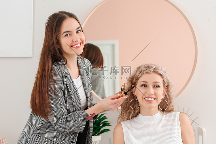 专业化妆艺术家与年轻女子在沙龙