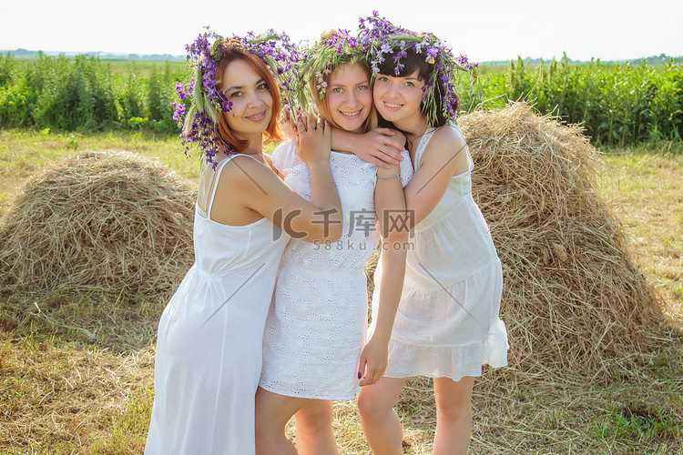三个年轻漂亮的姑娘在白色礼服和