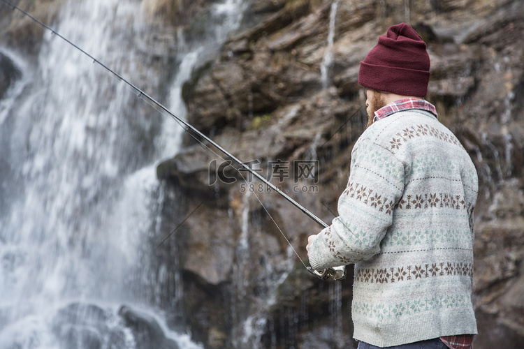 一名男子在瀑布边钓鱼