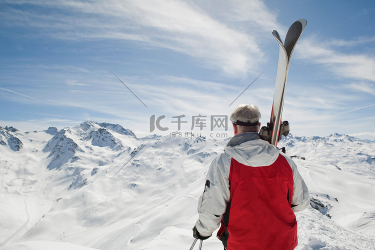 成年男子手持滑雪的背影