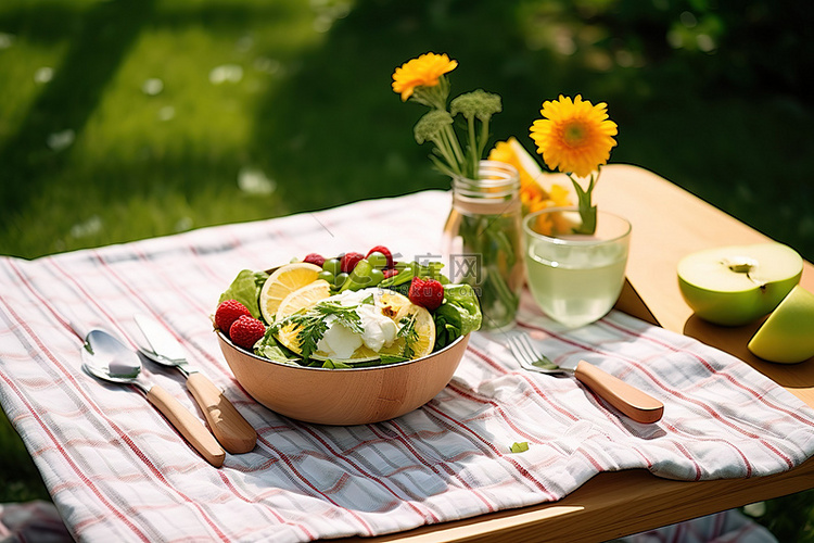 野餐桌上放着一碗水果和沙拉