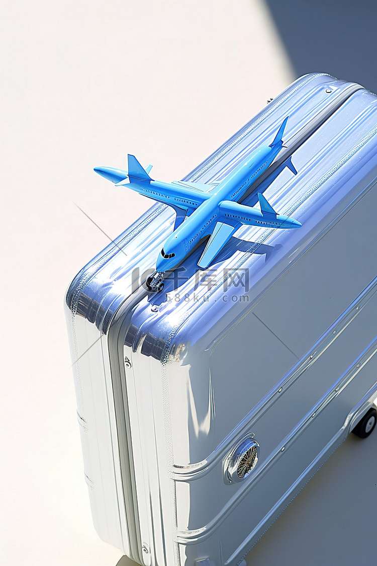手提箱旁边的一架蓝色模型飞机
