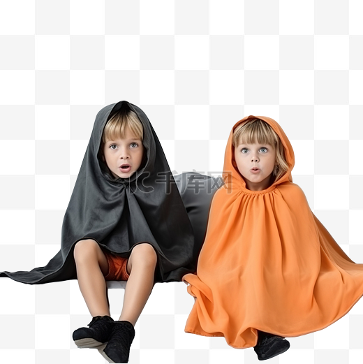 受惊的孩子们穿着万圣节服装坐在沙发上看恐怖电影图片