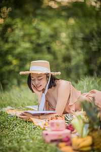 夏天户外野餐趴在地上看书的女孩