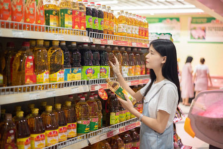 消费者人物摄影照片_挑选食用油