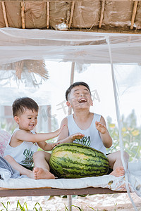 夏天瓜棚里的两个小孩子玩耍