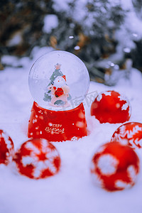 雪地里圣诞水晶球摄影图
