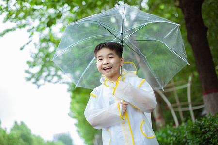 穿雨衣撑伞的男孩