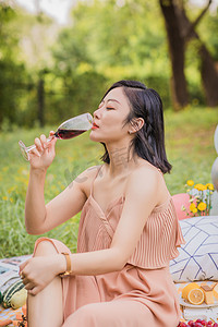 夏天户外野餐喝红酒的女孩摄影图