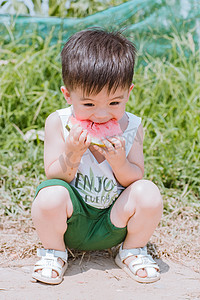 夏儿童摄影照片_西瓜地里吃西瓜的小男孩