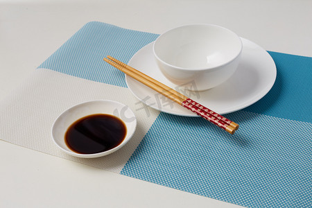 木头碗筷摄影照片_餐具碗筷子酱油餐垫摄影图