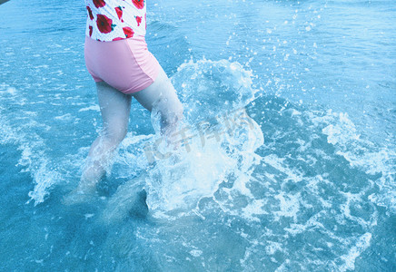 蓝色人物摄影照片_玩海水的女孩浪花朵朵