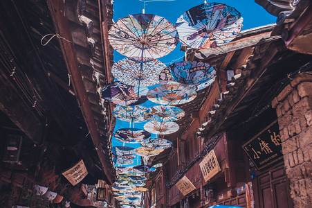 桃花源古镇摄影照片_古镇老巷里悬挂的油纸花伞摄影图