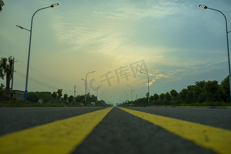 夏天落日下阳光马路摄影图