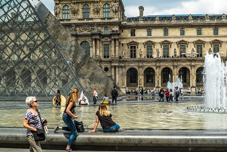 卢浮宫外观看喷泉的旅游者