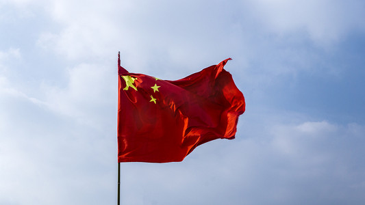 喜迎中国欢度国庆摄影照片_蓝天下舞动五星红旗自然风景摄影图